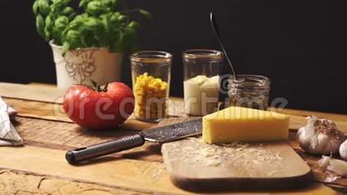 在木制<strong>餐桌</strong>上用新鲜的罗勒和多汁的<strong>番茄</strong>切碎奶酪